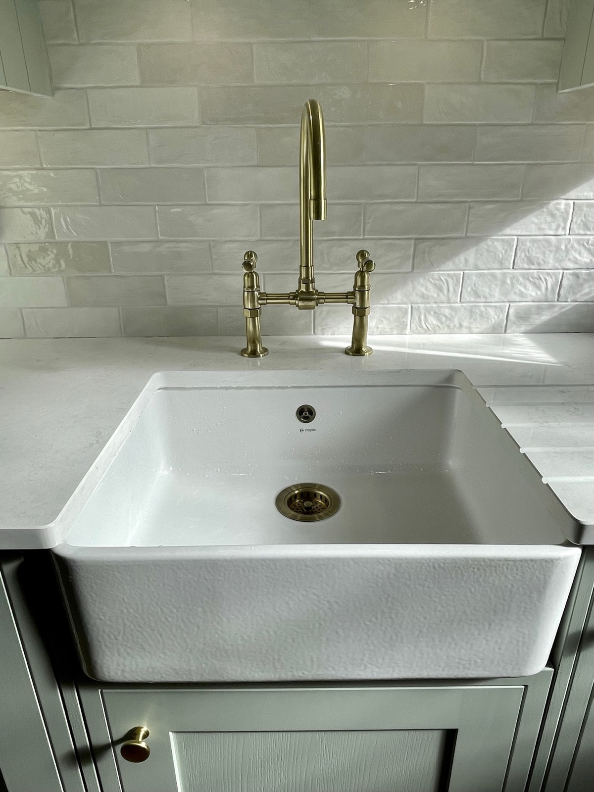 The ceramic sink and brass bridge tap up close