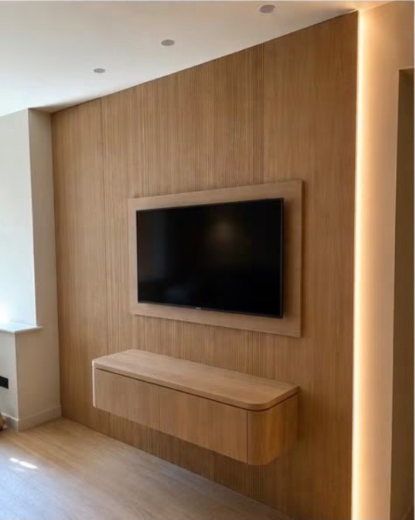 Fluted oak media wall with a floating unit and a lit edge